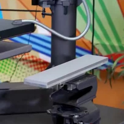 Máquina de prensagem térmica para têxteis com sistema rápido e aplicação em mangas.