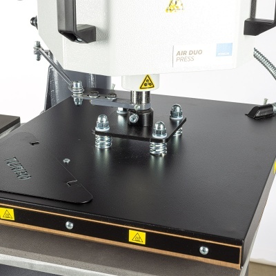 Máquina de prensa térmica branca e preta com etiquetas e sinais de aviso