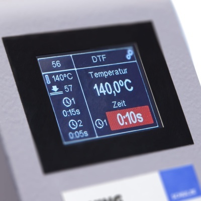 Ecrã digital com informações técnicas em alemão sobre temperatura e tempo.