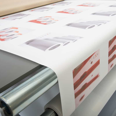 Papel impresso com padrão repetido a sair de rolo metálico de máquina
