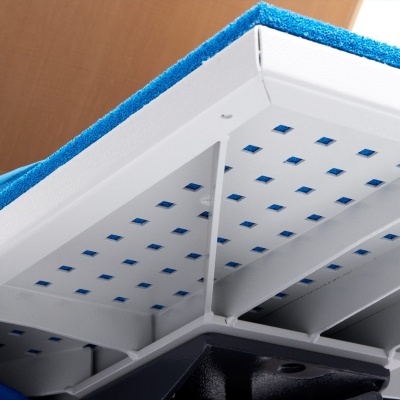 Parte inferior de estrutura branca com furos azuis e tecido azul por cima