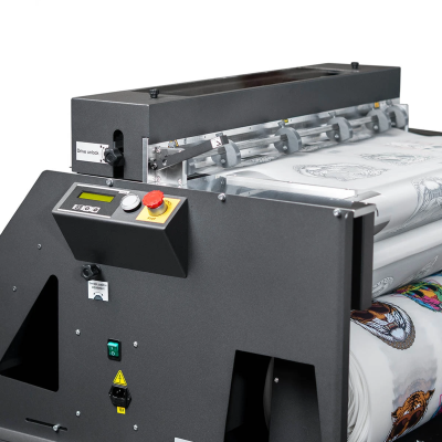 Máquina industrial cinza escuro a processar tecido com estampados