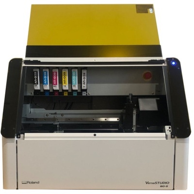 Impressora Roland VersaSTUDIO BN-20 com tinta colorida e tampa amarela aberta