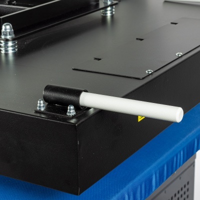 Máquina preta com alavanca branca e preta, parafusos prateados, tecido azul embaixo