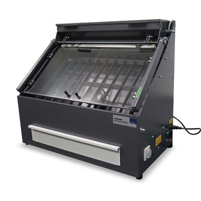 Máquina industrial preta com painel inclinado de vidro e divisórias internas