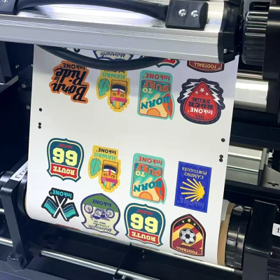 Folha com autocolantes coloridos a ser impressa numa impressora de grande formato