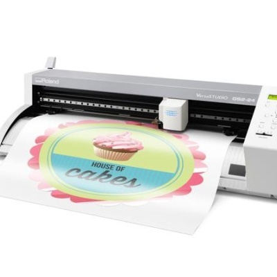 Impressora Roland a imprimir gráfico colorido com texto HOUSE OF cakes