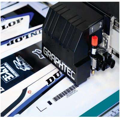 Impressora de recorte GRAPHTEC a processar decalques com logos e códigos de barras