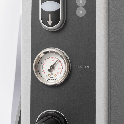 Manómetro de pressão com escala em bar e psi num painel cinzento de equipamento.