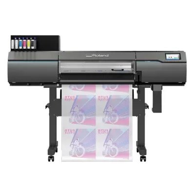 Impressora grande formato preta Roland a imprimir imagens coloridas de ciclistas no papel