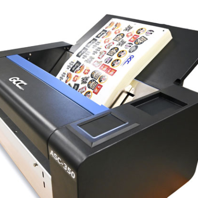 Impressora de etiquetas preta GCC ASC-350 com etiquetas coloridas saindo
