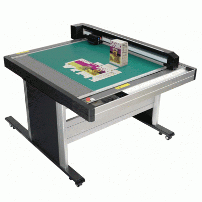 Mesa retangular cinza com superfície verde, dispositivo de leitura e cartões com caixa LEGADOMED