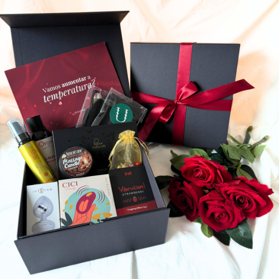 Kit 10 sensações | Vibrador de casal + lubrificante + cosméticos sensuais + acessórios Caixa de presente preta com laço vermelho e produtos íntimos variados com três rosas vermelhas ao lado.