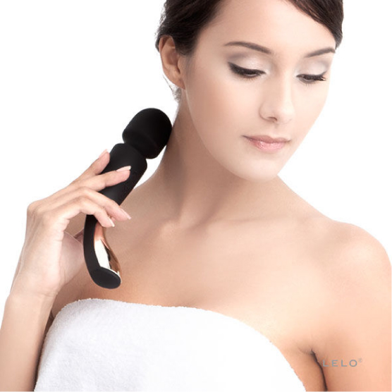 Lelo Smart Wand Medium - Varinha Mulher usando massageador preto no pescoço, com toalha branca
