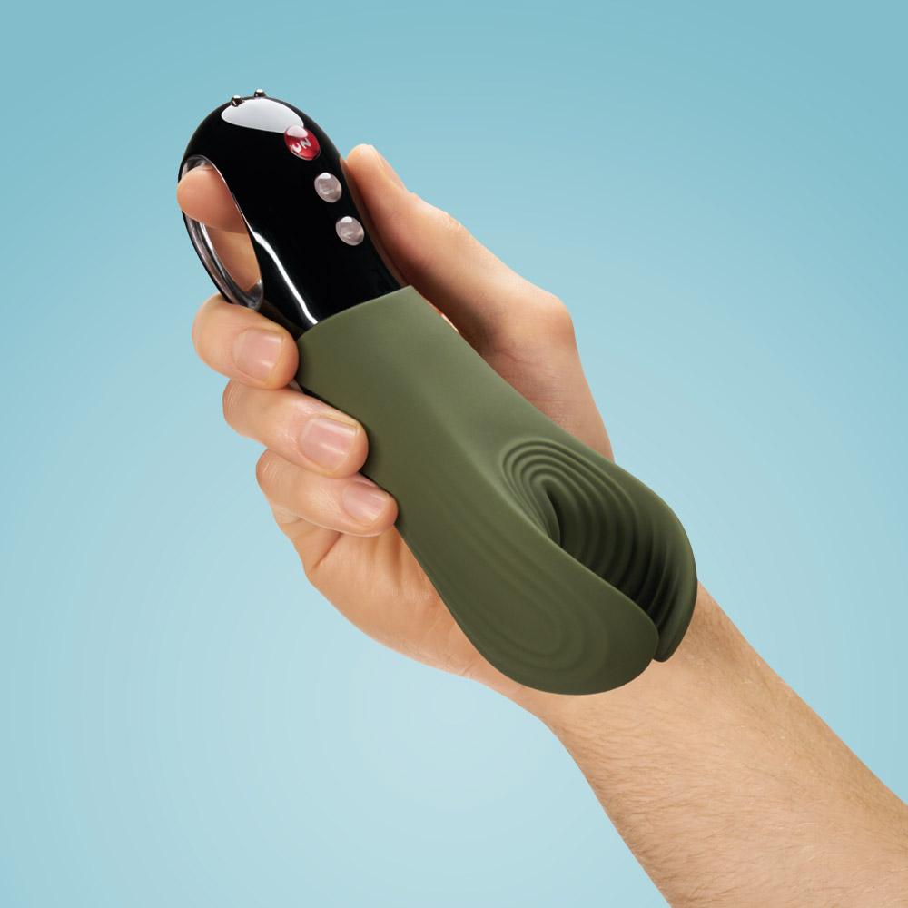 Manta Fun Factory | masturbador e vibrador de casal Dispositivo portátil verde e preto com cabo de argola prateado na mão