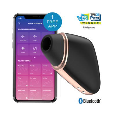 Dispositivo sexual preto com detalhes dourados e smartphone mostrando app para controle, fundo branco.