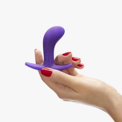 Plug anal roxo em mão feminina com unhas vermelhas