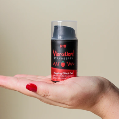 Frasco de gel Vibration! Strawberry da Intt na mão de uma pessoa com unhas vermelhas