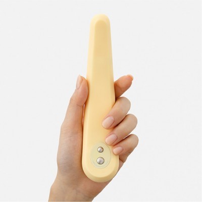 Mão a segurar um objeto amarelo claro com dois botões prateados