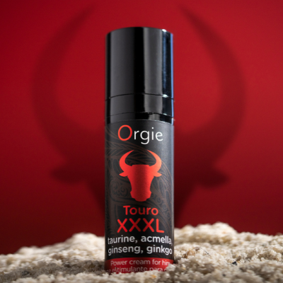 Frasco de creme estimulante Orgie Touro XXXL sobre superfície clara com fundo vermelho