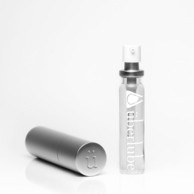 frasco spray transparente com tampa preta e caixa metálica prateada