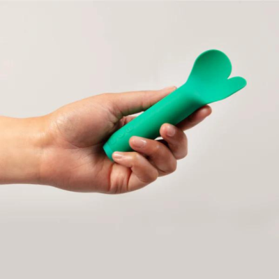 Dispositivo verde de silicone com formato ergonómico segurado numa mão