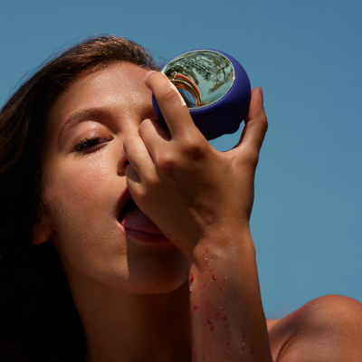 Mulher a usar dispositivo azul esférico com superfície espelhada