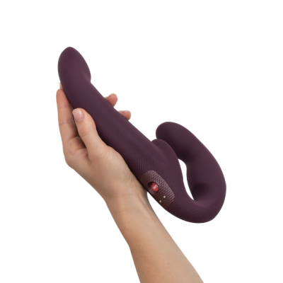 Vibrador roxo escuro em silicone segurado por uma mão