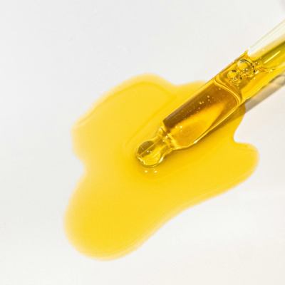 Pipeta de vidro com líquido amarelo derramado