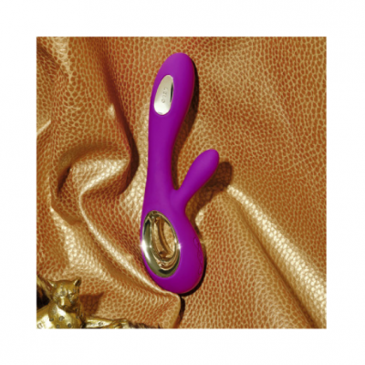 Vibrador roxo em silicone com detalhes prateados sobre tecido castanho com padrão animal print
