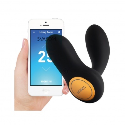 Dispositivo sexual preto com botão laranja SVAKOM ao lado de telemóvel branco com ecrã azul