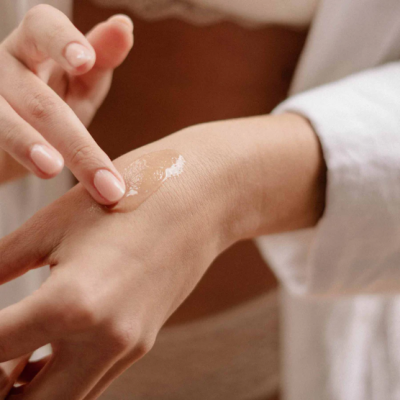 Pessoa a aplicar creme transparente na mão