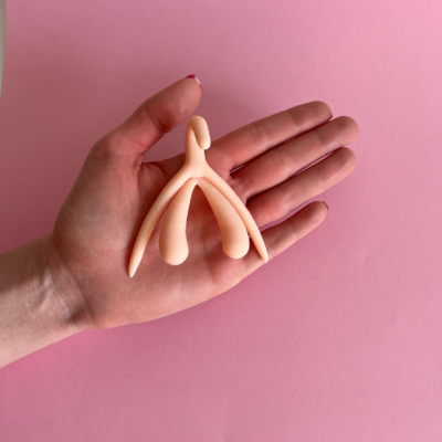 Objeto abstracto cor de pele em mão sobre fundo rosa