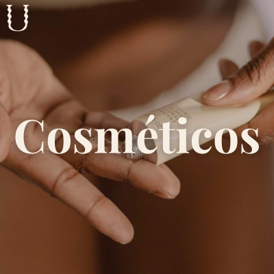 Mãos aplicando creme de embalagem branca pequena, fundo castanho desfocado