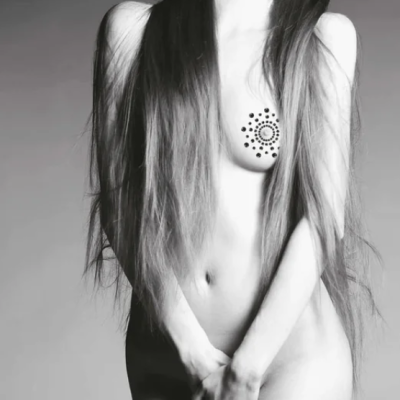 Mulher nua com tatuagem circular decorativa no peito e cabelo comprido