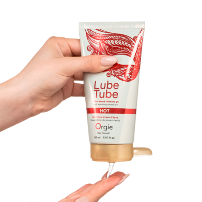 Tubo de gel íntimo Lube Tube HOT, embalagem branca e vermelha, tampa dourada, gel a escorrer para a mão