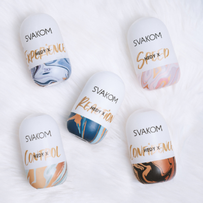 Cinco dispositivos eletrónicos SVAKOM com tampa branca e base marmoreada sobre superfície branca felpuda