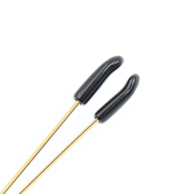 Dois pinos dourados com pontas pretas sobre fundo branco