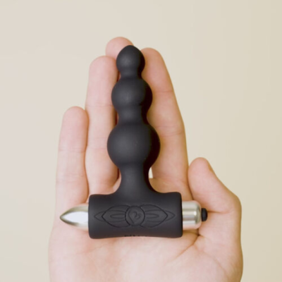 Plug anal preto em silicone com base metálica numa mão