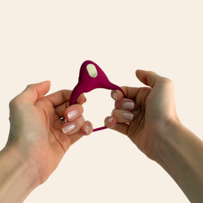 Anel elástico bordô com placa metálica segurado por mãos