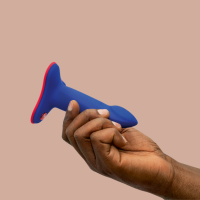 Produto azul com base vermelha na mão sobre fundo bege