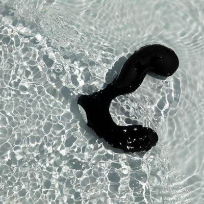 Produto preto curvo submerso em água clara com reflexos de luz