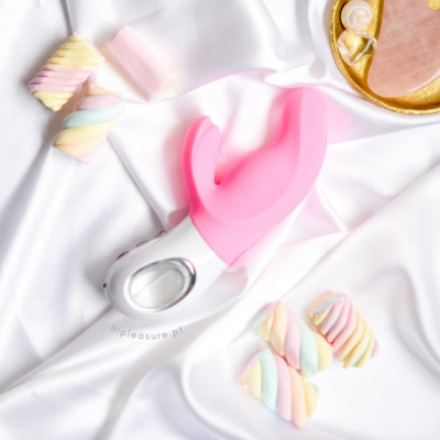 Vibrador rosa e branco em tecido branco com marshmallows coloridos e prato dourado com conchas e sabonete