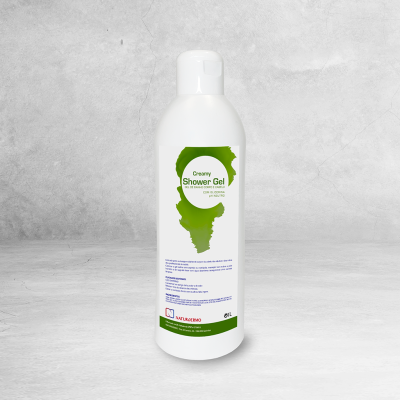 Frasco de gel de banho cremoso branco e verde sobre superfície cinzenta