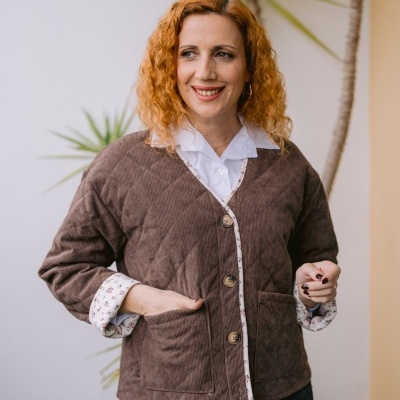 Casaco matelassê castanho com botões e acabamento floral em modelo feminino