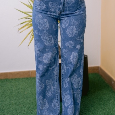 Calças de ganga azuis com padrão floral branco em fundo verde