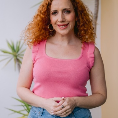 Mulher com blusa rosa e calças de ganga com bordados de coração e nuvem