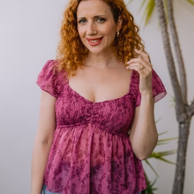 Blusa rosa com padrão floral e mangas bufantes usada por mulher com jeans azuis