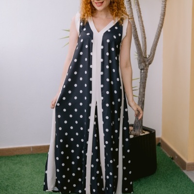 Vestido longo preto com bolinhas brancas e listas brancas usado por mulher ruiva