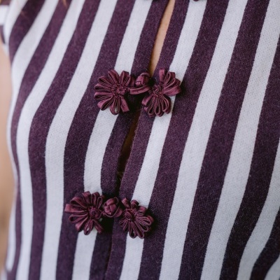 Blusa listrada branca e roxa com botões decorativos florais roxos